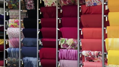 Close-up-of-colorful-big-rolls-of-fabric-samples-vertically-organized---interior-shot-with-camera-pan-movement-and-sharp-focus