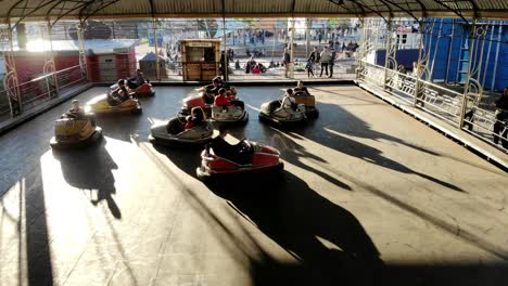 Kinder-Und-Jugendliche,-Die-An-Einem-Sonnigen-Tag-In-Montevideo,-Uruguay,-4k-Video-In-Elektrischen-Autoscootern-Im-Themenvergnügungspark-Spielen