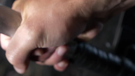 Sliding-close-up-shot-of-a-hand-gripping-gym-barbell-getting-ready-to-lift
