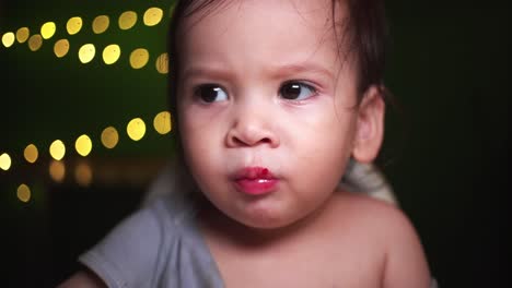 Baby-Junge-Rack-Focus-Pull-Isst-Obst-Mit-Goldenem-Bokeh-Im-Dunklen-Raum-Glücklich-Und-Lächelnd