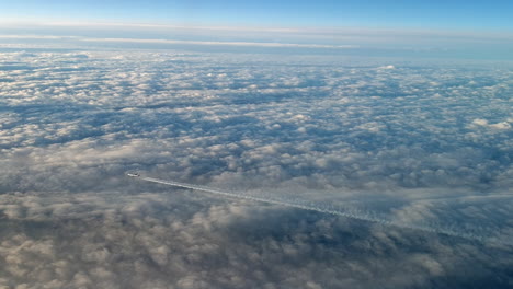 Unglaubliche-Aussicht-Aus-Dem-Cockpit-Eines-Flugzeugs,-Das-Hoch-über-Den-Wolken-Fliegt-Und-Eine-Lange-Weiße-Kondensdampf-Luftspur-Am-Blauen-Himmel-Hinterlässt