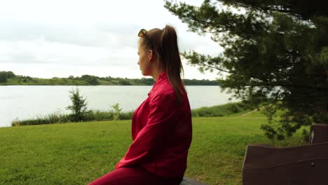 Girl-sitting,-looking-out-to-the-lake