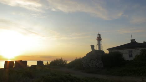 Schöne-Aussicht-Auf-Den-Pape-Leuchtturm-An-Einem-Ruhigen-Sommerabend-Mit-Langsam-Ziehenden-Wolken-Vor-Dem-Sonnenuntergang,-Weitwinkelaufnahme