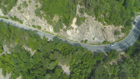 Drone-Chasing-Silver-car-on-rocky-mountain-passage-road-in-Bulgaria