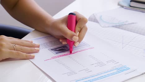Left-handed-Girl-Using-A-Pink-Marker-In-Highlighting-Her-Homework---Close-up-Shot