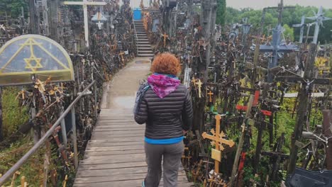 A-shot-following-a-woman-in-Hill-of-crosses,-Lithuania