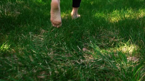 Girl's-feet-walking-through-grass-in-slow-motion