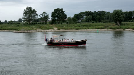 Río-Ijssel,-Países-Bajos,-Mostrando-Un-Barco-Navegando-Por-El-Río.