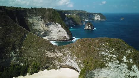 Drone-Shot-of-KelingKing-Beach-panning-up-and-revealing-the-beautiful-cliffs-of-the-island-of-Nusa-Penida,-Indonesia