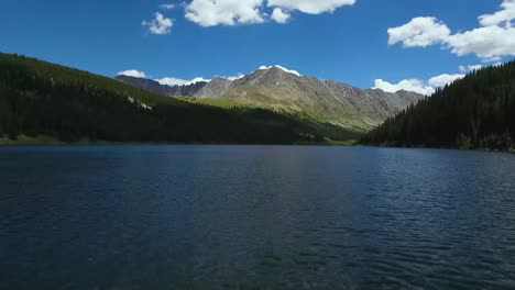 AERIAL:-Drone-flies-over-blue-lake-in-front-of-a-beautiful-Colorado-mountain