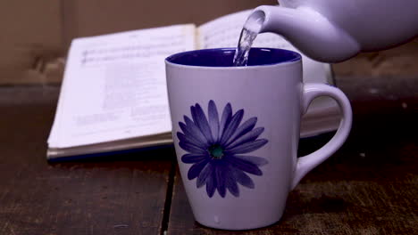 Pouring-a-cup-of-coffee-with-an-out-of-focus-book-in-the-back-ground