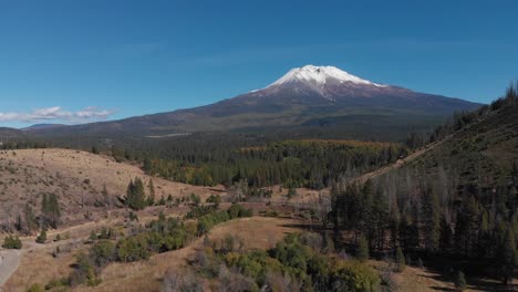 Rising-aerial-view-of-snow-capped-Mount-Shasta-and-preceding-highway