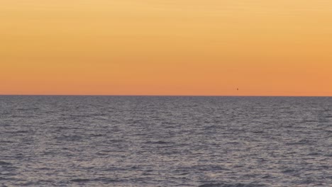 Beautiful-view-of-the-calm-Baltic-sea-after-the-sunset-in-summer,-medium-shot-from-a-distance
