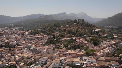 AERIAL:-Discover-pan-of-mediterranean-city-between-hills-in-mallorca