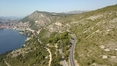 Aerial-shot-of-Dubrovnik-hills-and-roads-with-Old-Town-in-the-distance
