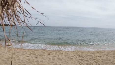 Sombrillas-Marrones-En-La-Playa-Con-Una-Suave-Brisa-Durante-Un-Día-De-Verano-Parcialmente-Soleado