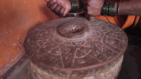 Indische-Frau-Gießt-Dal-In-Eine-Handmühle