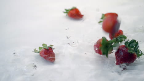 SLOMO-of-Strawberries-Falling-into-Water-on-White-Backdrop