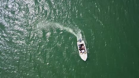 Luftaufnahme-Von-Oben-Nach-Unten,-Kamerafahrt-Eines-Motorbootes,-Das-Im-Kreis-Davonrast