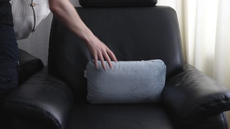 Taking-pillows-out-of-a-black-armchair