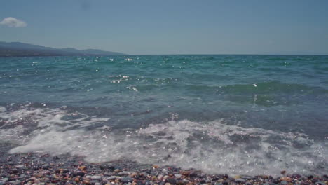 Beruhigende-Wellen-Am-Strand-Von-Kalamata,-Griechenland-Slowmo-Schwenk-Von-Links-Nach-Rechts