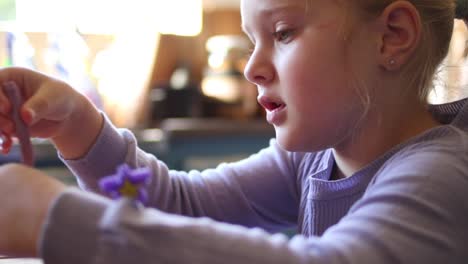 Close-up-footage-of-a-young-five-year-old-girl-playing-with-clay-in-the-kitchen-of-the-house-she-lives-in