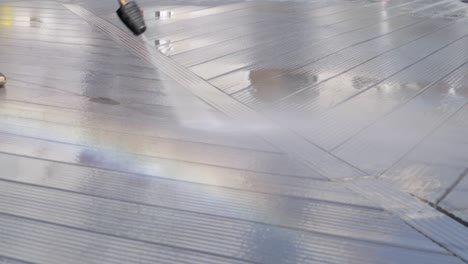Wasserdruckstrahlreiniger-Reinigt-Das-Schwarze-Deck-Und-Erzeugt-Mit-Dem-Sommertageslicht-Einen-Regenbogen
