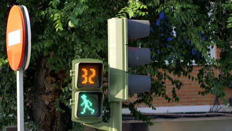A-red-man-figure-turning-green-man-walking-figure-in-a-traffic-light,-starts-a-countdown-from-30-seconds,-and-reappears-red-man-figure