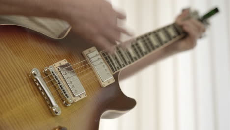 Shallow-DoF-close-up-of-a-male-musician's-hands-playing-a-sunburst-electric-guitar