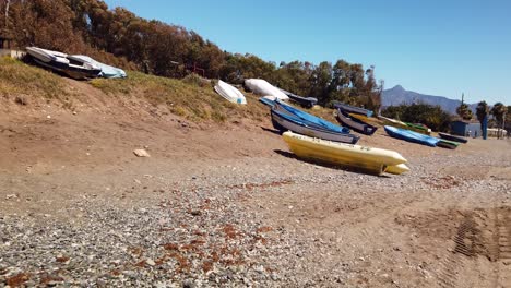 small-fishing-boards-on-the-beach-in-spain,-costa-del-sol,-marbella,-malaga,-spain