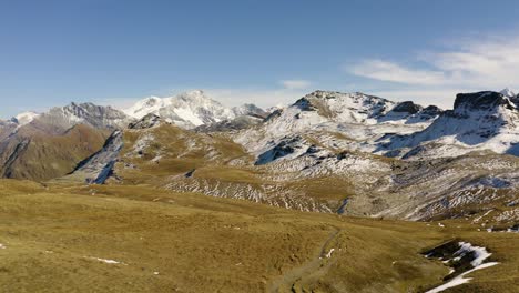 Tiefflug-über-Den-Bergpfad,-Am-Ende-Erscheint-Ein-Blauer-See,-Alpine-Landschaft,-Erster-Schnee-Und-Herbstfarben
