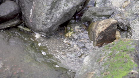 Wasser-Fließt-Vom-Wasserfall-Zum-Fjord-Zwischen-Felsen