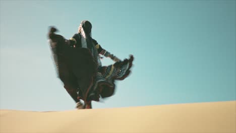 Gypsy-woman-walking-on-a-desert-sand-dune