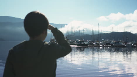 Woman-silhouetted-as-she-looks-out-at-a-marina-in-British-Columbia,-Canada