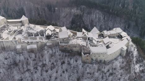 Aerial-slide-of-Rasnov-Citadel-in-Romania,-during-winter-time
