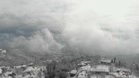 Luftaufnahmen-Von-Schneebedeckten-Bergen,-Traditionelles-Dorf-In-Griechenland-2