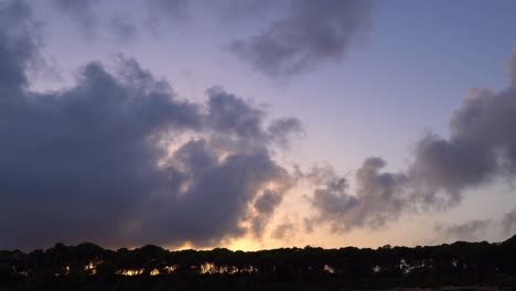 Fast-moving-clouds-over-treeline-at-sunset-on-the-Spanish-island-of-Mallorca