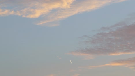 Distant-airplane-flying-up-in-the-sky-during-sunset