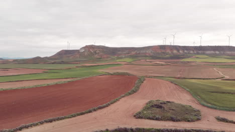 Rotes-Und-Grünes-Ackerland-Mit-Einigen-Windmühlen-Am-Horizont