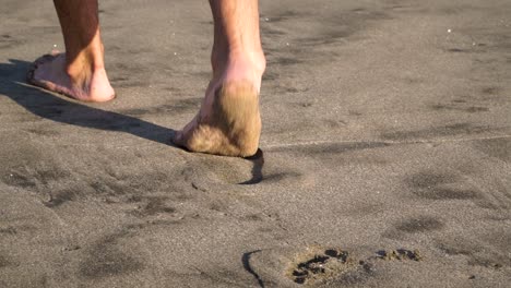 SLOWMO---Close-up-of-feet-from-behind-walking-on-beach