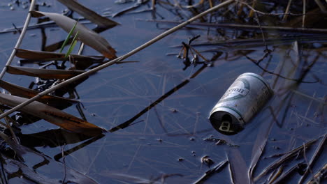 A-Medium-Shot-of-Old-White-Beer-Can-Thrown-Out-in-the-Shallow-Part-of-the-Lake