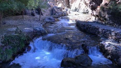 Wide-shot-of-a-creek-with-a-small-waterfall-at-Atlas-Mountains,-Morocco