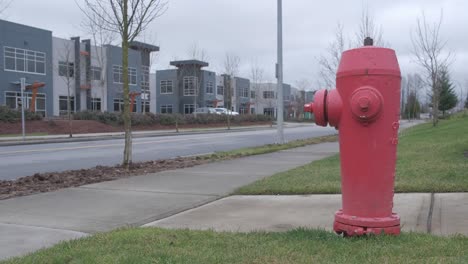 Fire-hydrant-in-a-small-industrial-area-with-cars-driving-in-the-background