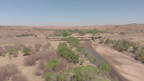 aerial-over-a-dry-river-with-a-bridge