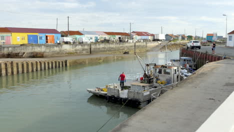 Große-Ansicht,-Austernzüchter-Arbeiten-Auf-Dem-Deck-Ihres-Plattbodenbootes-Nach-Einem-Ausflug-Aufs-Meer,-Hafen-Von-Saint-Trojan-les-Bain,-Insel-Oleron