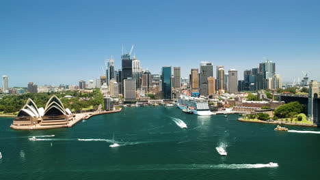 Aerial-cityscape-of-Sydney-Harbour,-Opera-house,-Circular-Quay-and-Sydney-river-with-ferries-crossing
