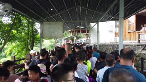 Zhangjiajie,-China---August-2019-:-Massive-tourist-crowds-in-a-extremely-long-queue-to-the-bus-pick-up-inside-the-Zhangjiajie-National-Park,-Hunan-Province