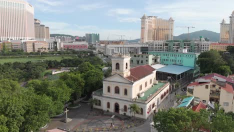 Drone-orbit-shot-of-church-in-Taipa-Village-with-casinos-in-background