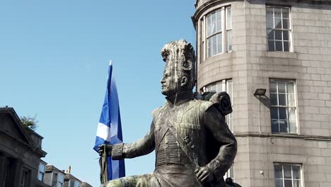 Slow-motion-of-a-Gordon-Highlanders-Statue-holding-the-Saltire-at-a-pro-Scottish-Independence-march