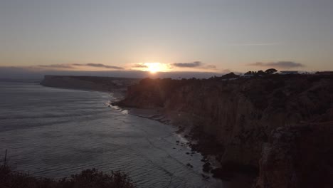 Die-Letzten-Strahlen-Des-Sonnenuntergangs-Silhouette-Lagos-Küstenklippen,-Portugal,-Breit